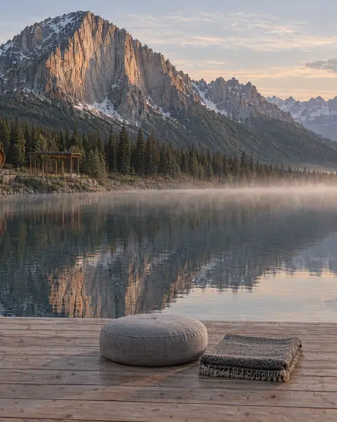 Das Deck am See auf der Alm: Sitzkissen am Wasser im Morgenlicht